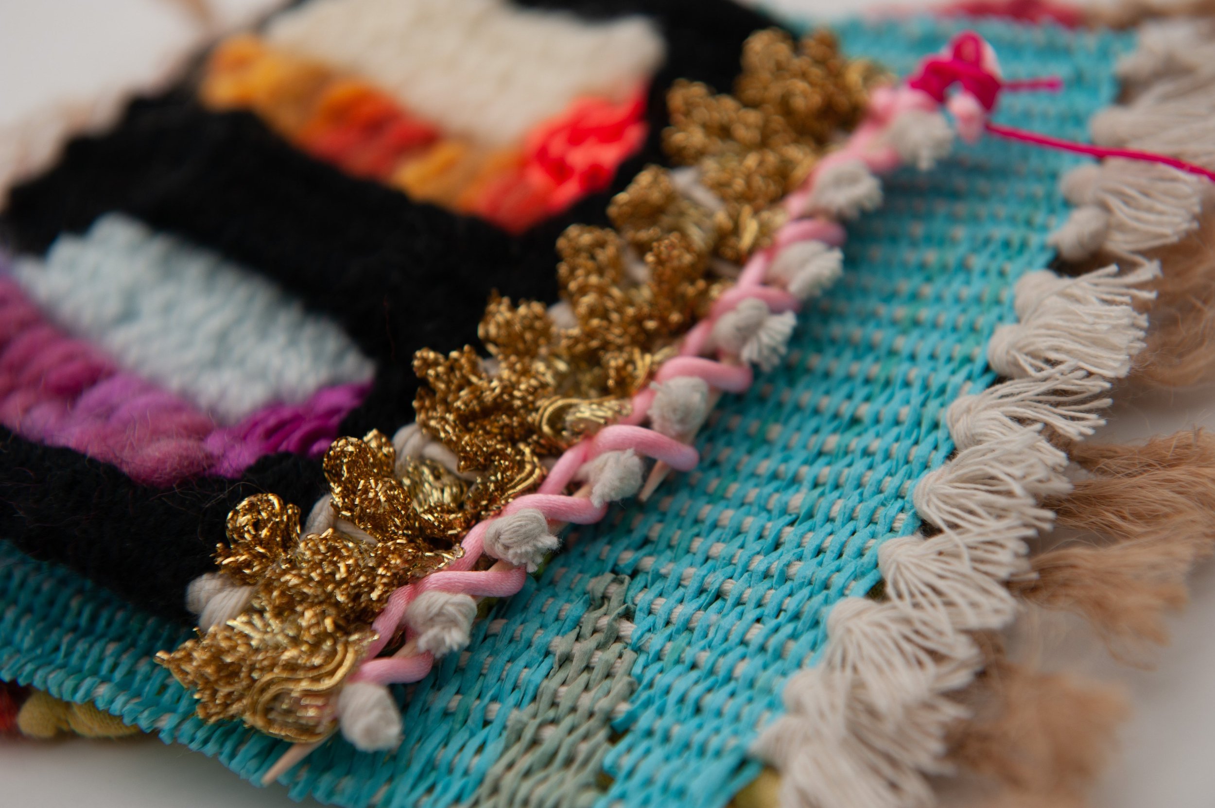 Close-up detail of textured woven loops and gold fringes